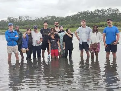 Touristes marchant dans les eaux peu profondes de la lagune Aby